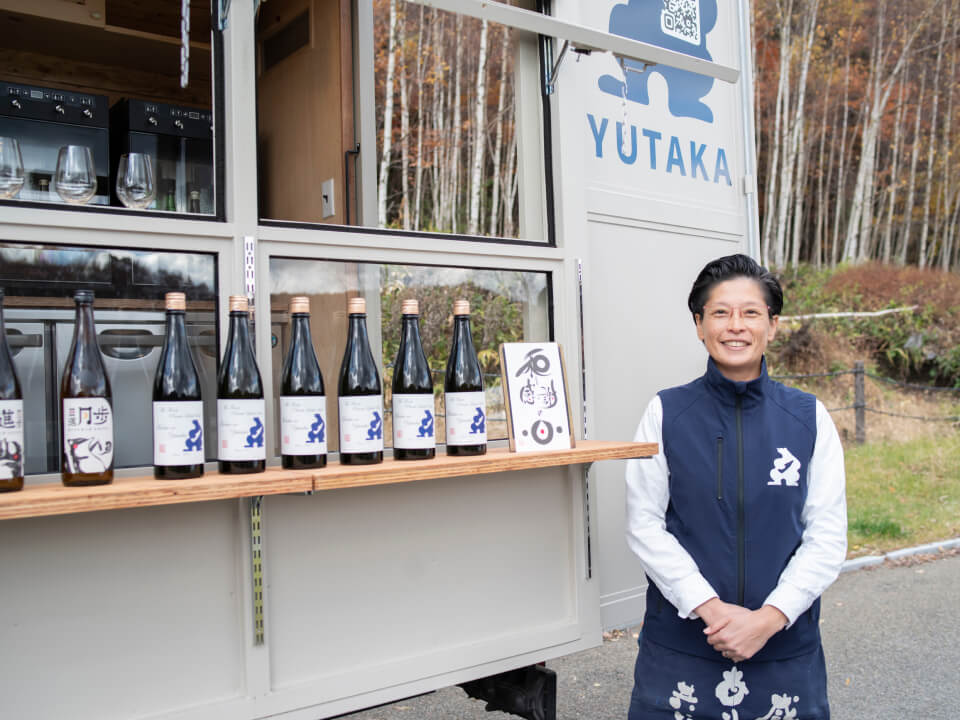 酒トラックの前で微笑む男性