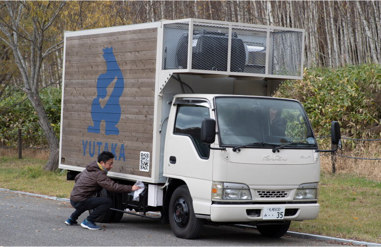 酒トラックの整備をする男性